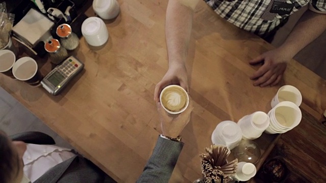 咖啡师给客人递咖啡。从上面看视频素材
