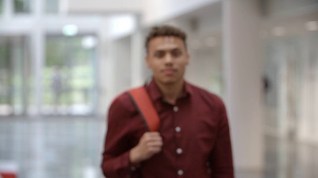 一名男大学生走进一个现代化的大厅视频素材
