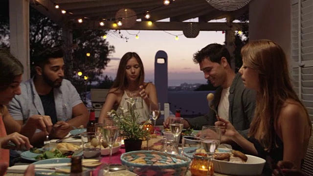 伊比沙岛(Ibiza)，朋友们在屋顶露台上的晚餐聚会上聊天，这是用R3D拍摄的视频素材