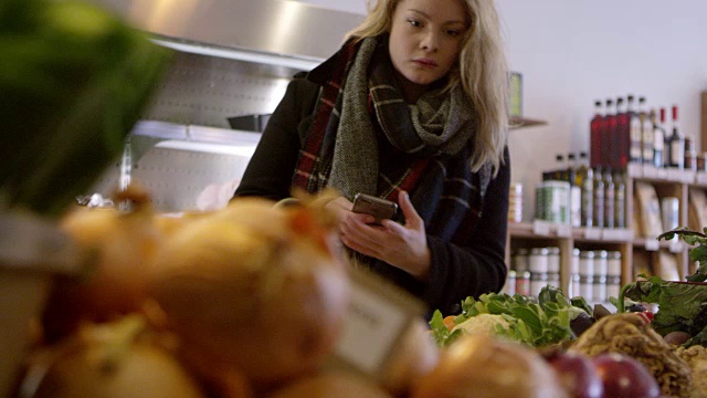 在熟食店用R3D拍摄的手机上有名单的女人视频素材