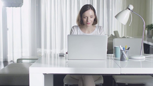 女人在家里用笔记本电脑工作。视频素材