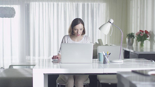 女人在家里用笔记本电脑工作。视频素材
