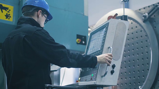 工厂工人正在用平板电脑为数控铣床编程。视频素材