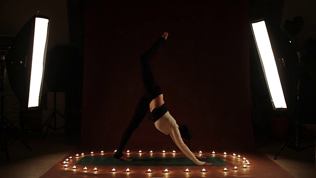 年轻的白人女子在烛光下做瑜伽视频下载