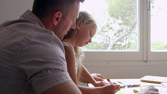 女儿与父亲画在桌子上拍摄的R3D视频素材