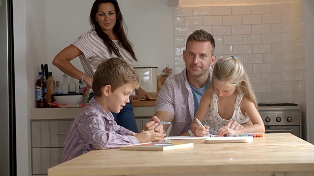 父母在餐桌上帮助孩子做作业视频素材