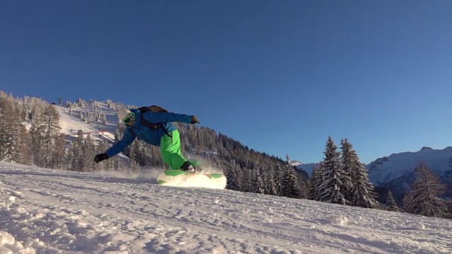 慢镜头:在阳光明媚的早晨，滑雪者在滑雪场上喷雪视频下载