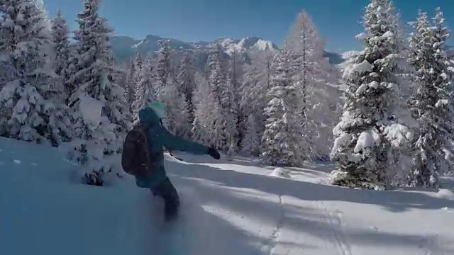 近景:滑雪女子在雪山中骑着新鲜的粉末雪视频素材