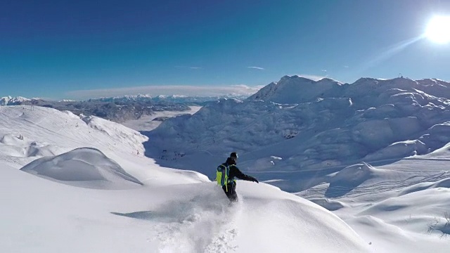 快乐的滑雪板有乐趣骑在雪山雪道上的粉末雪视频素材