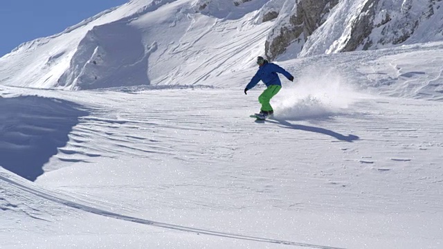 慢镜头:滑雪者在新雪中滑雪，将雪喷向镜头视频素材
