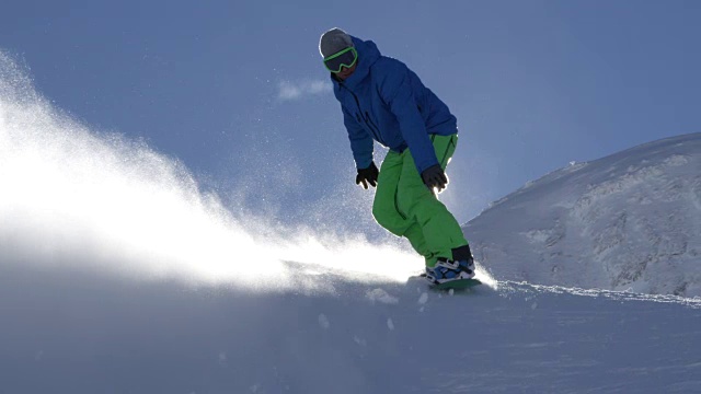 慢动作:滑雪者在新雪上滑雪，在阳光下喷洒粉末视频素材