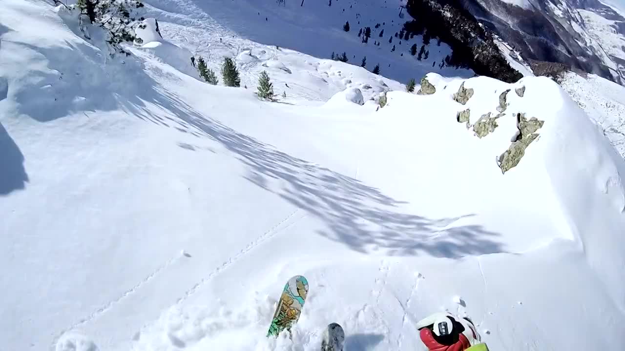 滑雪者从陡峭的山坡上滑雪，跳过岩石的突出部分视频购买
