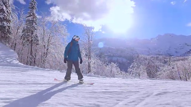 滑雪女孩在阳光明媚的高山滑雪场滑雪斜坡上滑雪视频素材