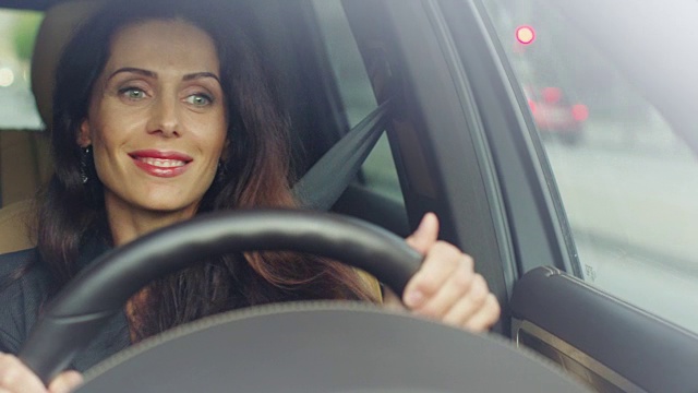 兴奋迷人的女商人一边开车一边听音乐。视频素材