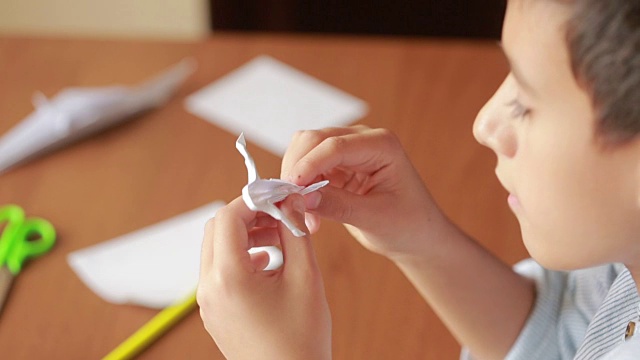 小男孩在纸上画折纸艺术。爱好工艺品视频下载