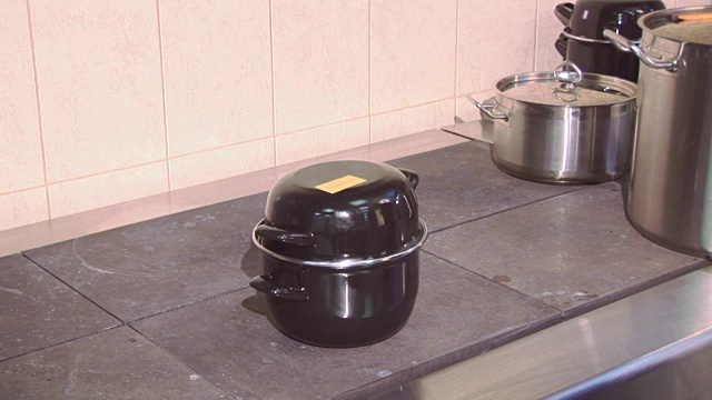 在餐厅厨房的工作炉上用统一的有盖平底锅做饭。烹饪的菜视频下载