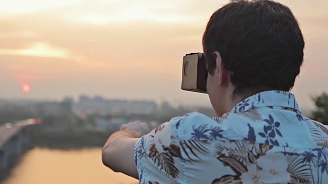 一名男子在日落时佩戴虚拟现实眼镜视频素材