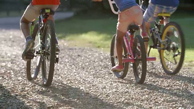 在农村一起骑自行车的孩子的后视图视频素材
