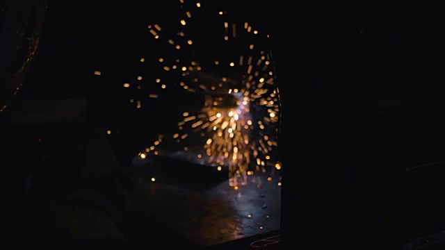 工人在黑暗中焊接金属结构。火花四处飞溅视频素材