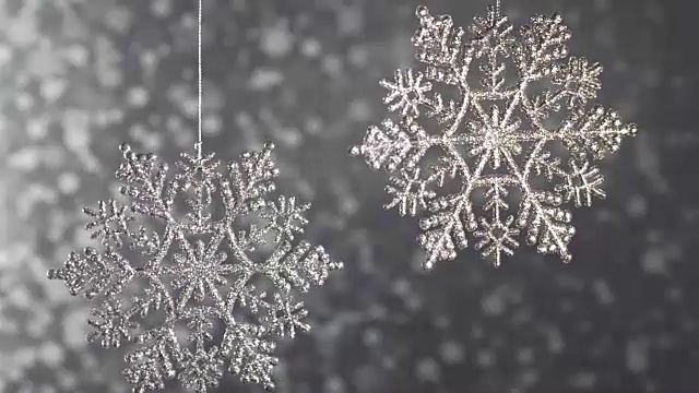 银色的钻石闪闪发光的雪花在银色的背景上散景。视频下载
