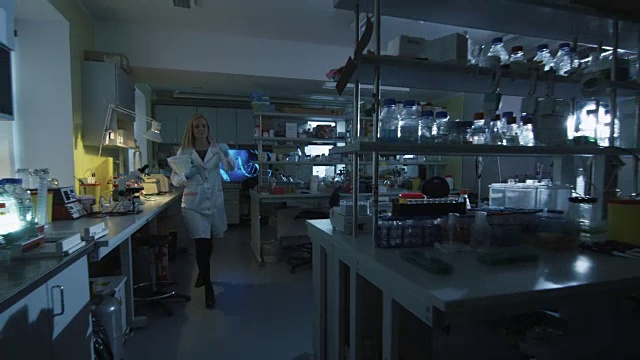 金发女科学家走进实验室，打开了灯。视频素材