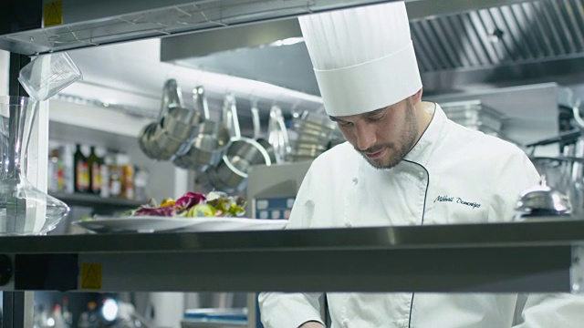 饭店或酒店商业厨房的专业厨师正在切绿色蔬菜。视频素材