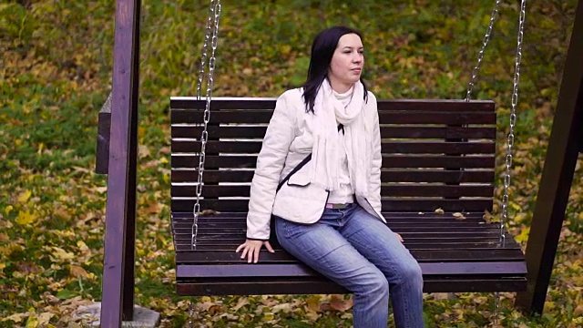 一个女人在公园里荡秋千视频素材