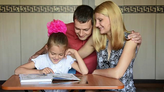 爸爸走到妈妈和女儿面前，她们正坐在一张桌子旁读入门书视频下载