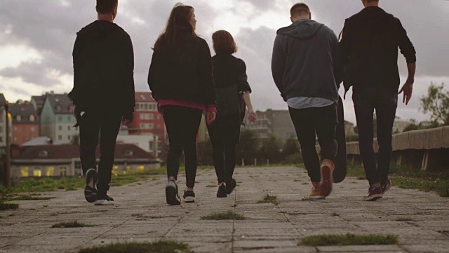 城市环境中向前走摄影机的五名快乐少年组。视频素材