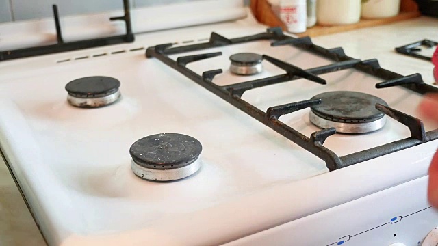 一个妇女在打扫厨房时洗煤气炉视频素材
