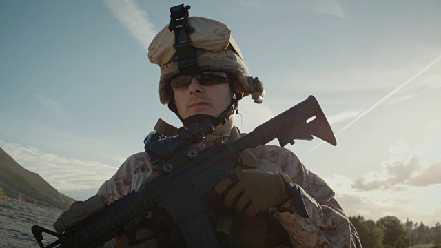 肖像的全面装备焊锡持有突击步枪和站在沙漠环境视频下载