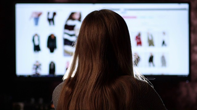 后视图的女人网上购物与电脑视频购买