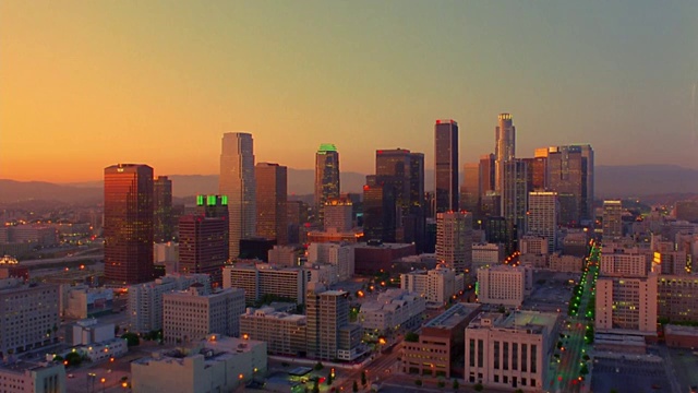 高角度广角拍摄时间推移城市街道上的交通与办公大楼/黄昏到夜晚/洛杉矶，加利福尼亚州视频素材