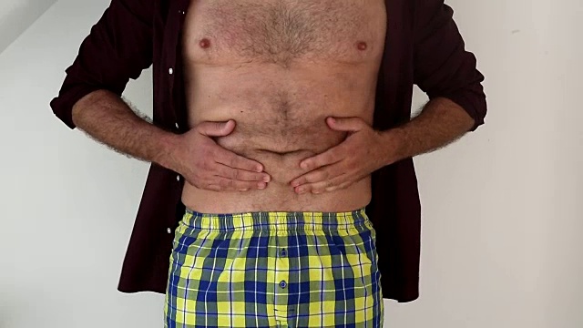 一个男人摸着他的胖肚子的特写视频下载