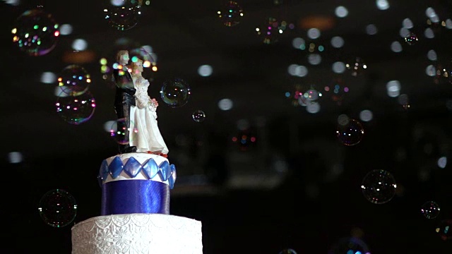 婚礼蛋糕上有新郎和新娘的形象，还吹着泡泡视频下载