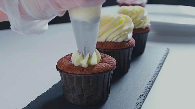 女人的手把奶油涂在蛋糕上，家庭烘焙的概念视频素材