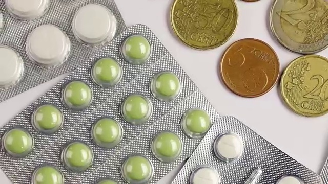 药丸和硬币孤立在白色背景视频下载