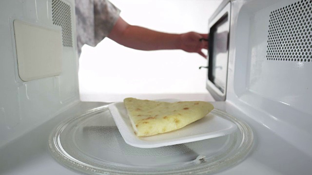把剩下的奶酪派放到微波炉里的泡沫盘上重新加热视频下载