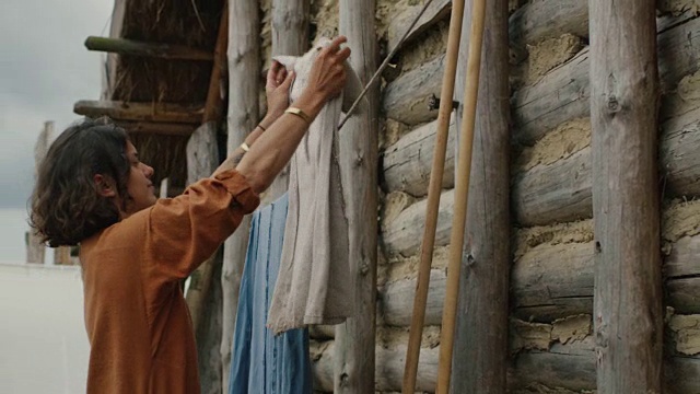 村民的生活。穿着中世纪服装的女人挂衣服。中世纪的产物。视频素材