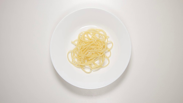 俯视图:白色盘子上的意大利面和酱汁-放，吃(定格动作)视频素材