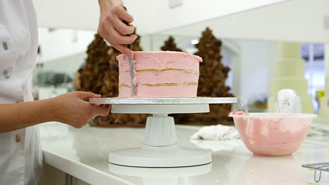 面包店的女人用糖衣装饰蛋糕视频素材