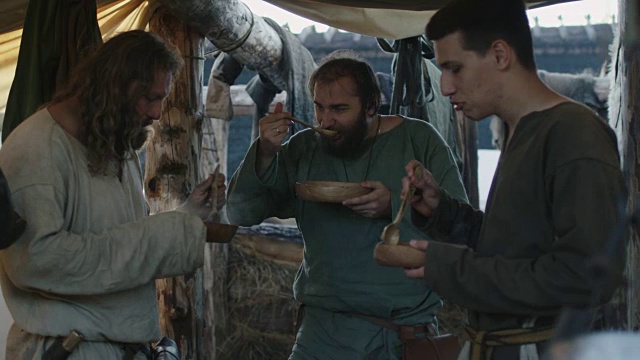 穿着中世纪服装的男人在吃。村民的生活。中世纪的产物。视频素材