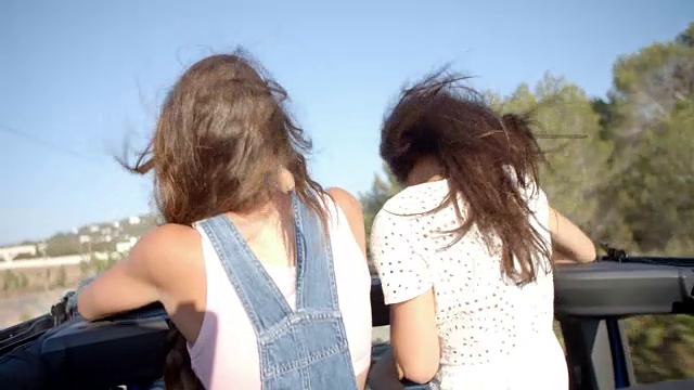 两个女性朋友站在一辆行驶的汽车后座上视频素材