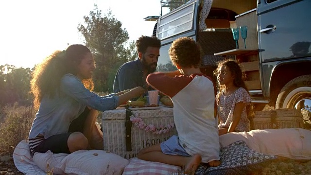 日落时分，一家人在露营车外野餐视频购买