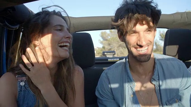三个快乐的朋友在一辆敞篷车的后座上旅行视频素材