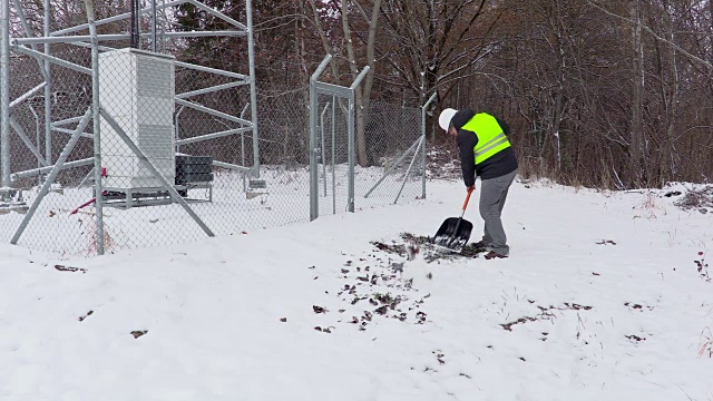 工人用雪铲在栅栏附近工作视频下载