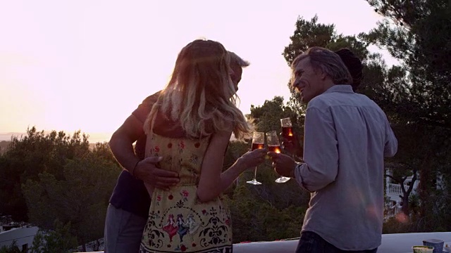 日落时分，两对情侣在屋顶上敬酒，拍摄了R3D视频素材