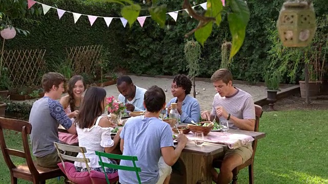 朋友吃和喝在户外派对桌子上拍摄的R3D视频素材