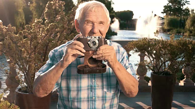 年长男性拿着相机。视频下载