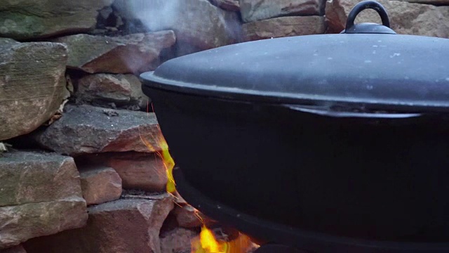 用铸铁锅在火上煮肉。视频下载
